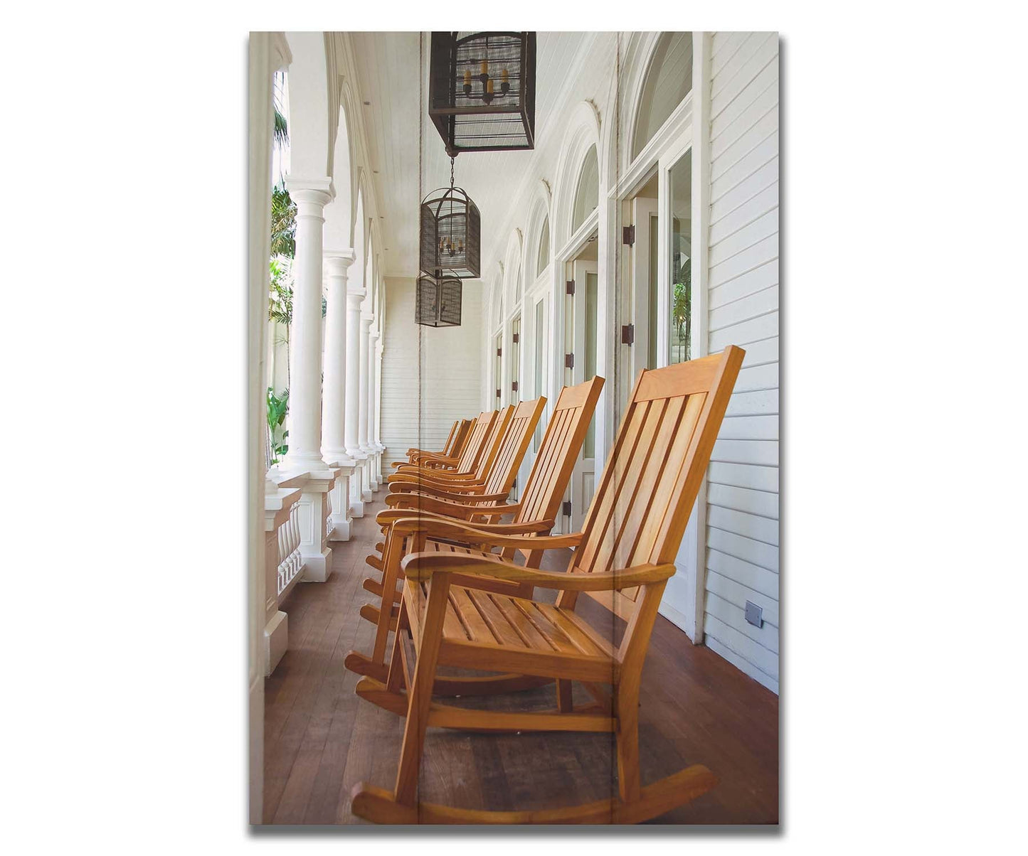 A photo looking down a row of rocking chairs on a porch in O'ahu, Hawaiʻi. Printed on a box board.