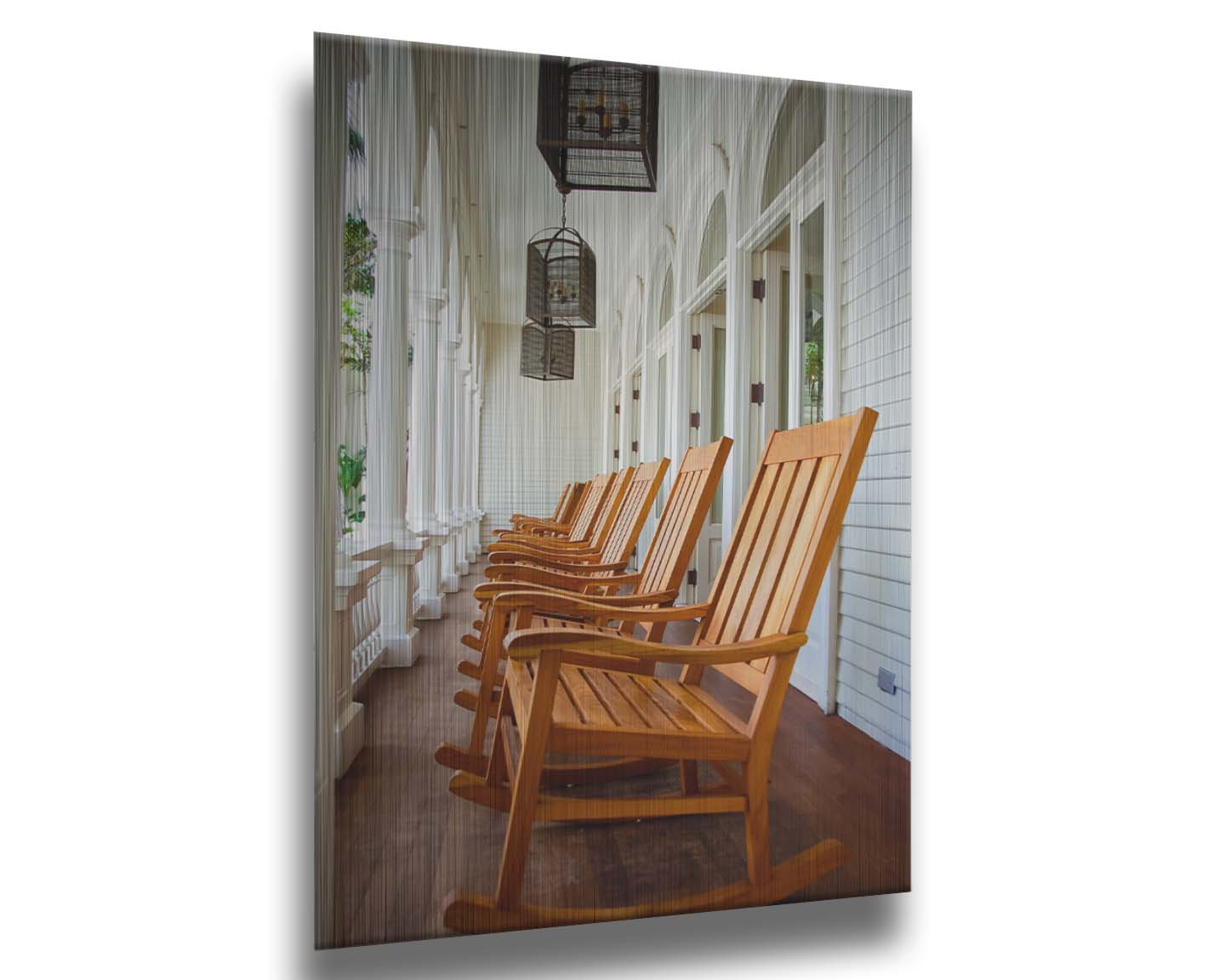 A photo looking down a row of rocking chairs on a porch in O'ahu, Hawaiʻi. Printed on metal.