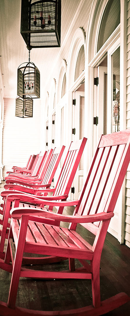 A photo looking down a row of rocking chairs on a porch in O'ahu, Hawaiʻi. 