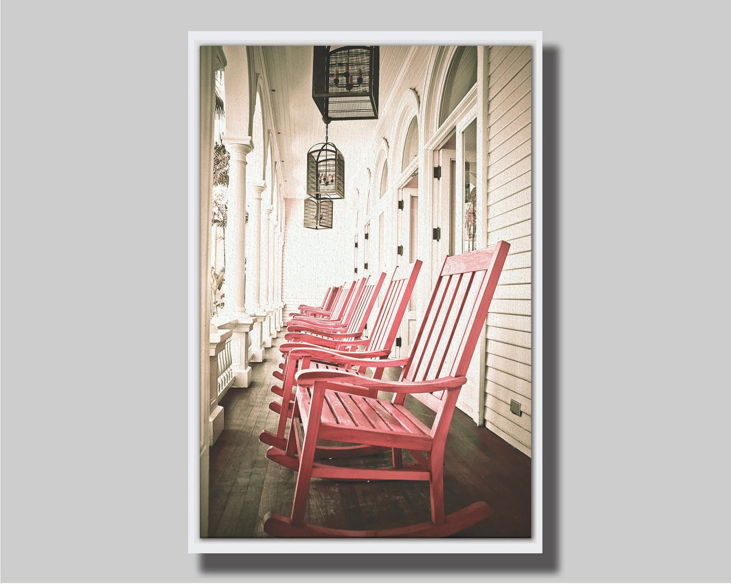 A photo looking down a row of rocking chairs on a porch in O'ahu, Hawaiʻi. Printed on canvas in a float frame.