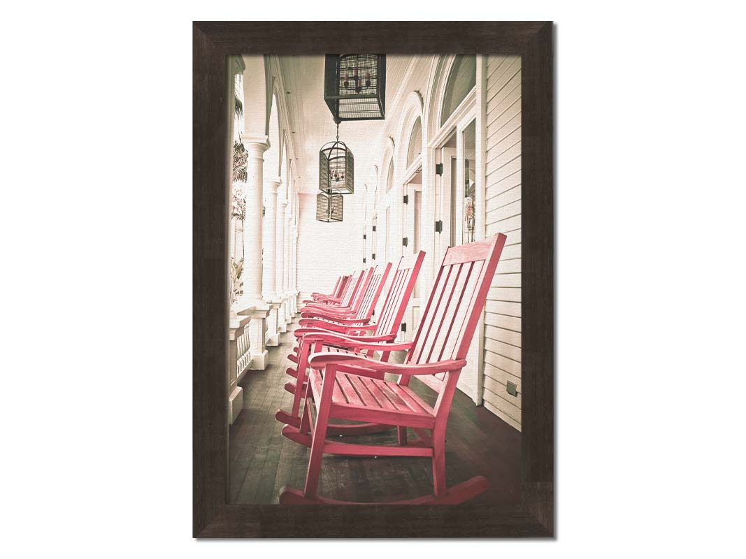 A photo looking down a row of rocking chairs on a porch in O'ahu, Hawaiʻi. Printed on canvas and framed.