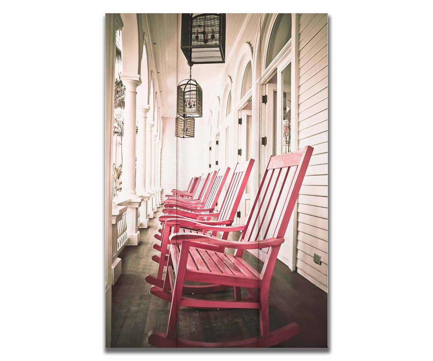 A photo looking down a row of rocking chairs on a porch in O'ahu, Hawaiʻi. Printed on a box board.