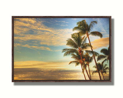 Photograph of palm trees set against the morning sky by the orange hues of the sunrise. Printed on canvas in a float frame.