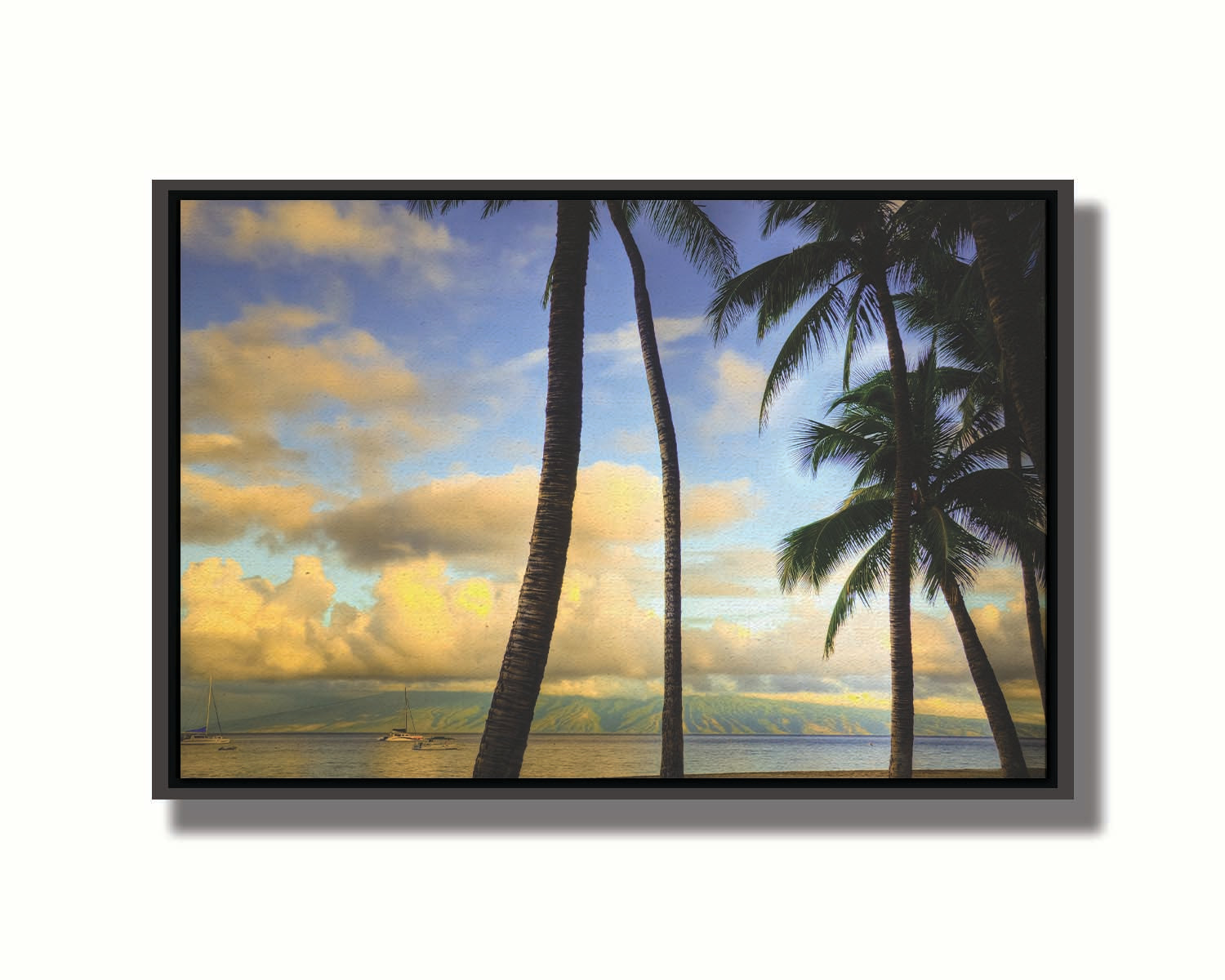 A photo of a collection of palm trees, backed by a view of the sea and distance mountainous islands lit with yellow from the low sun. Printed on canvas in a float frame.