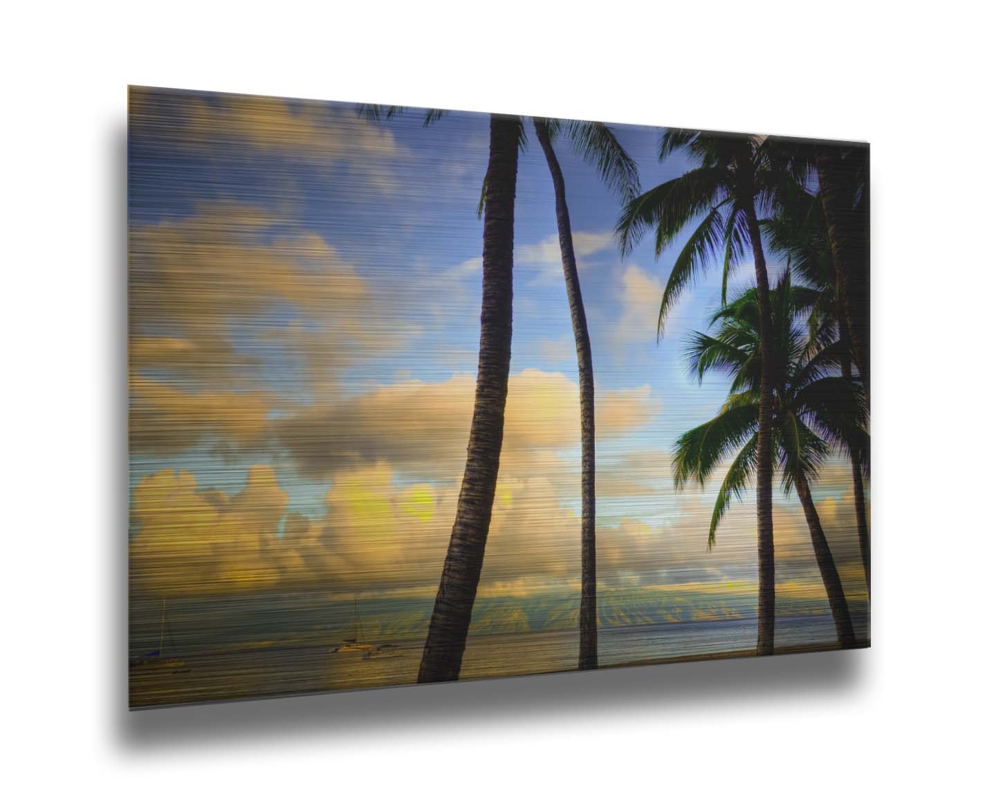 A photo of a collection of palm trees, backed by a view of the sea and distance mountainous islands lit with yellow from the low sun. Printed on metal.