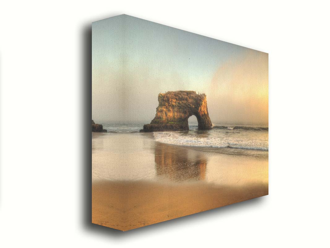 A photo of a "natural bridge" rock formation in Santa Cruz, California. A group of pelicans sit on top of the structure above the sea. Printed on canvas.