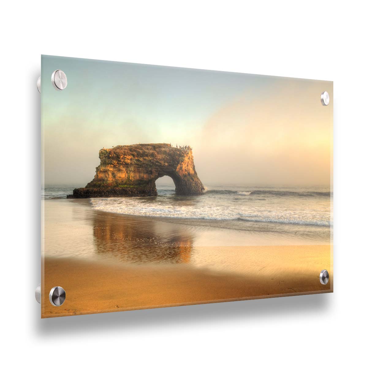 A photo of a "natural bridge" rock formation in Santa Cruz, California. A group of pelicans sit on top of the structure above the sea. Printed on acrylic.