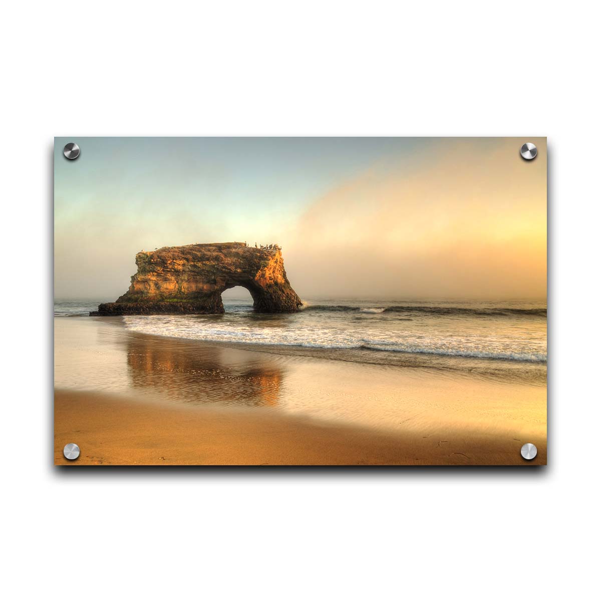 A photo of a "natural bridge" rock formation in Santa Cruz, California. A group of pelicans sit on top of the structure above the sea. Printed on acrylic.