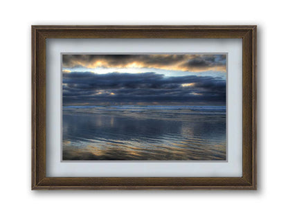 A photo of the sea at La Jolla as viewed near the Ellen Browning Scripps Memorial Research Pier. Rays of light can be seen shining down onto the sea from the cloudy sky. Printed on paper, matted, and framed.