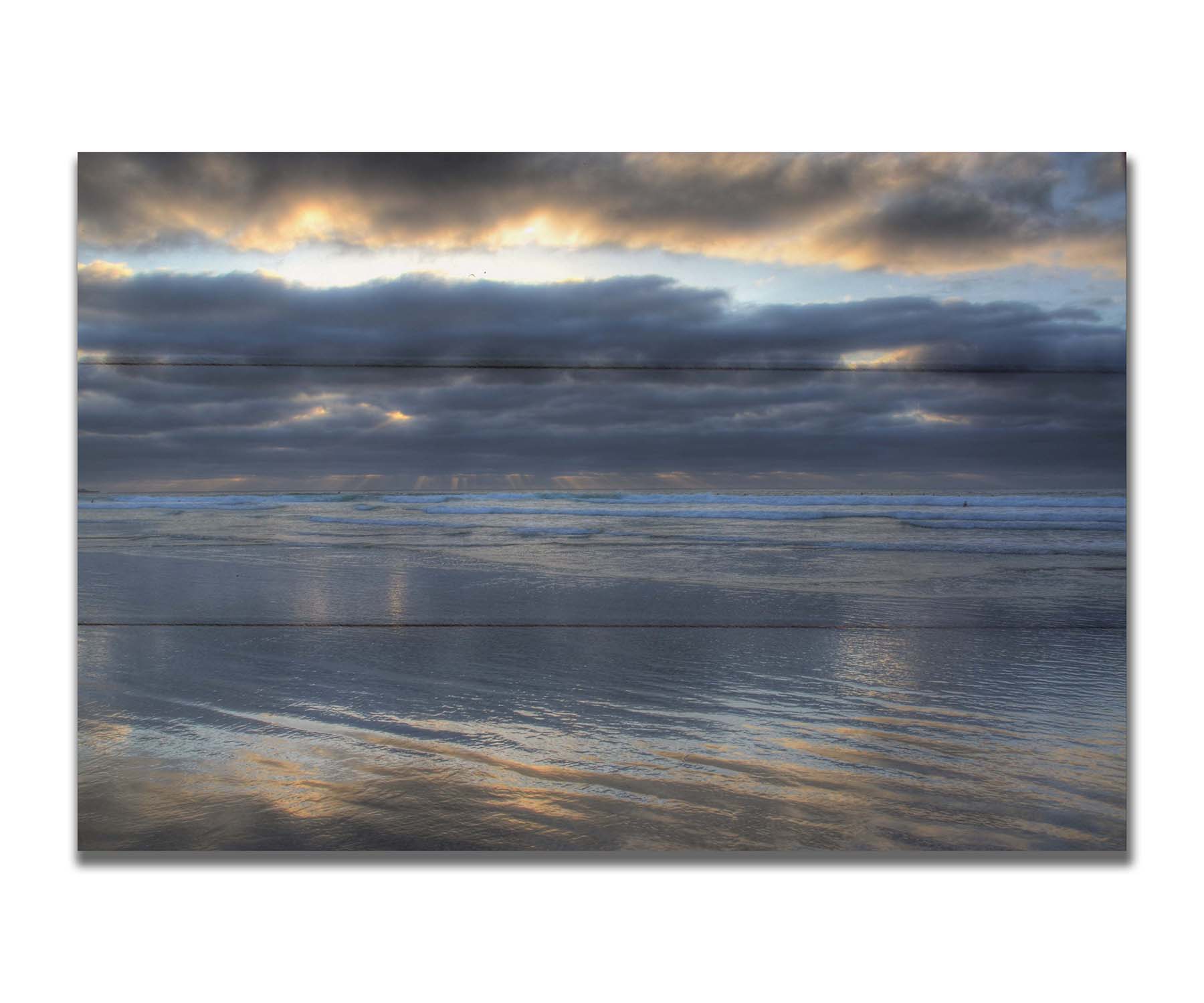 A photo of the sea at La Jolla as viewed near the Ellen Browning Scripps Memorial Research Pier. Rays of light can be seen shining down onto the sea from the cloudy sky. Printed on a box board.