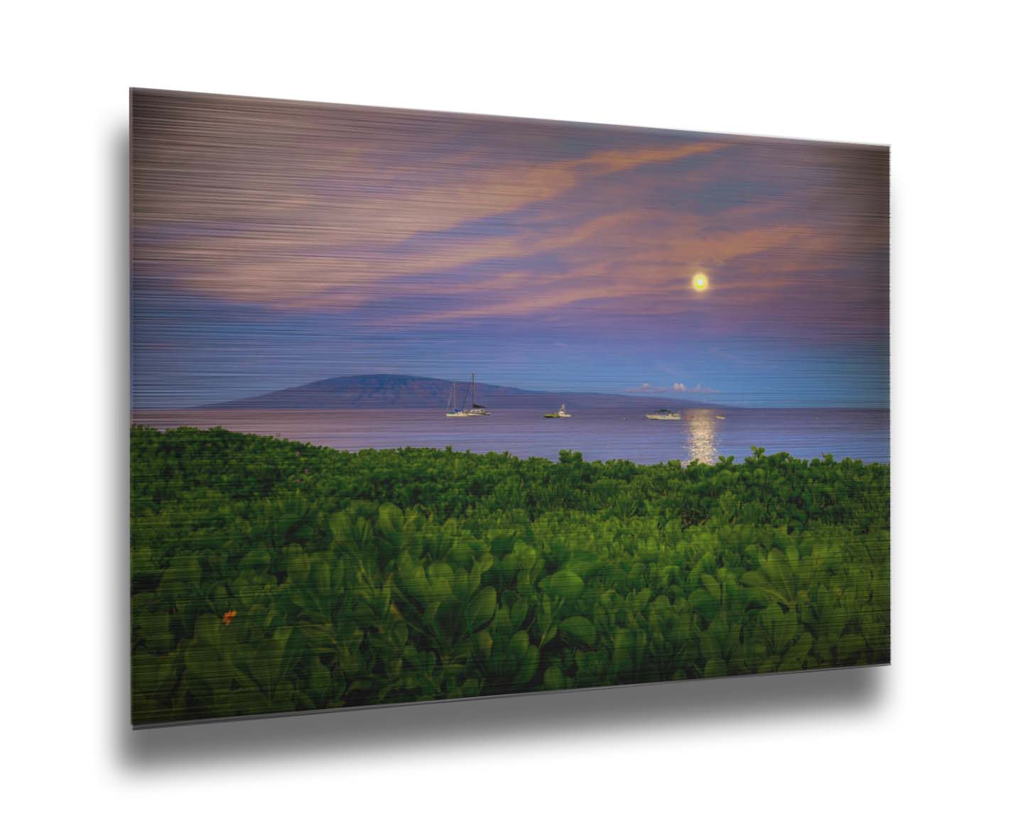 A photo overlooking the sea off the coast of Hawaiʻi as the moon sets. The foreground is filled with greenery, and ships can be seen sailing on the waters with mountains in the distance. Printed on metal.