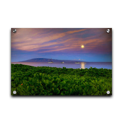 A photo overlooking the sea off the coast of Hawaiʻi as the moon sets. The foreground is filled with greenery, and ships can be seen sailing on the waters with mountains in the distance. Printed on acrylic.