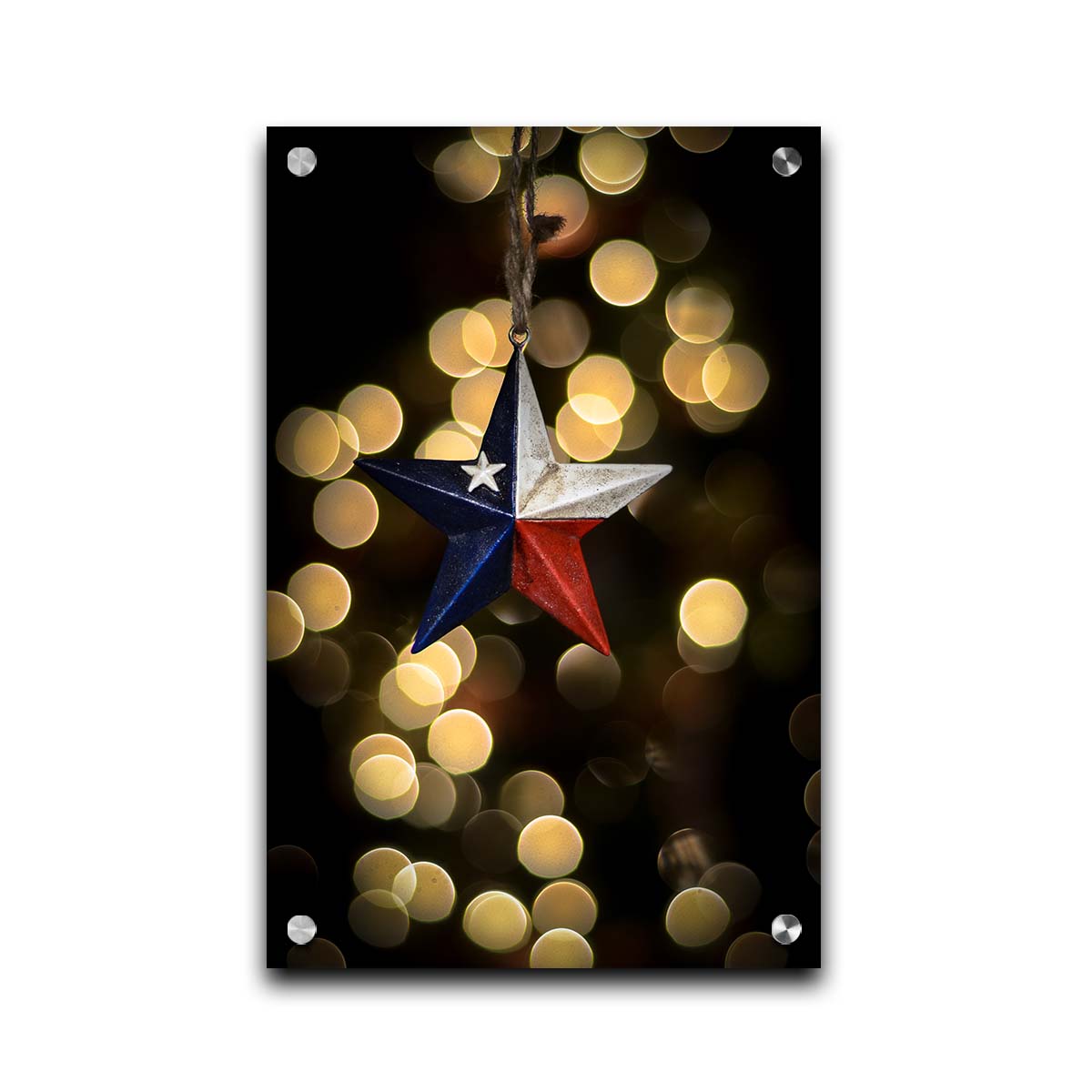 A photo of a christmas ornament of a star painted like the Texas state flag, with yellow bokeh in the background. Printed on acrylic.