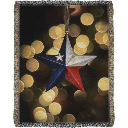 A woven throw blanket printed with the image of a star-shaped texas flag christmas ornament.