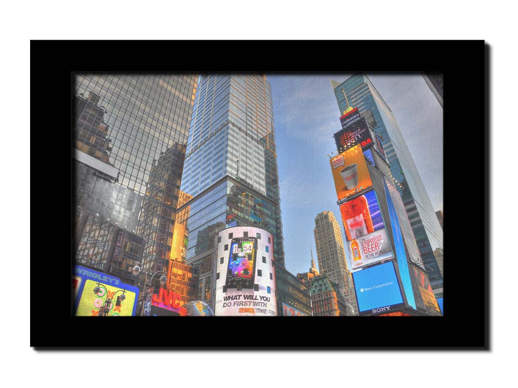 A photo looking up at the buildings and advertisements of Times Square in New York. Printed on canvas and framed.