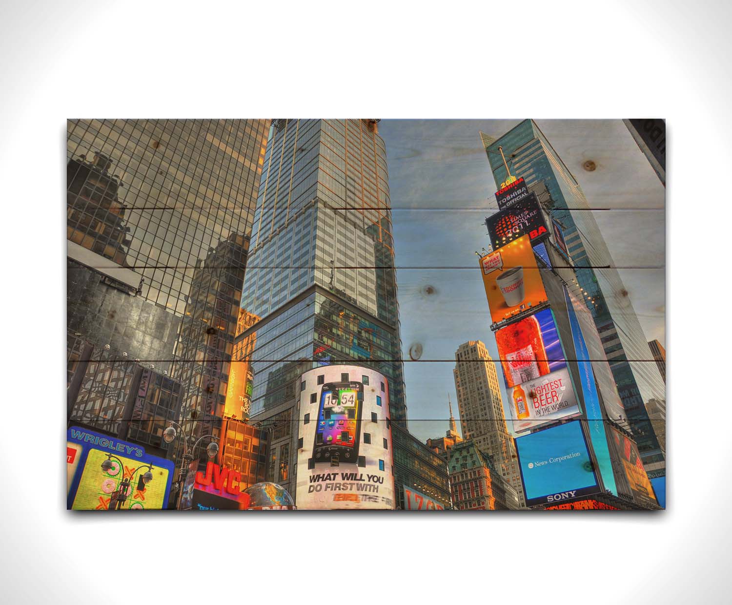 A photo looking up at the buildings and advertisements of Times Square in New York. Printed on a wood pallet.