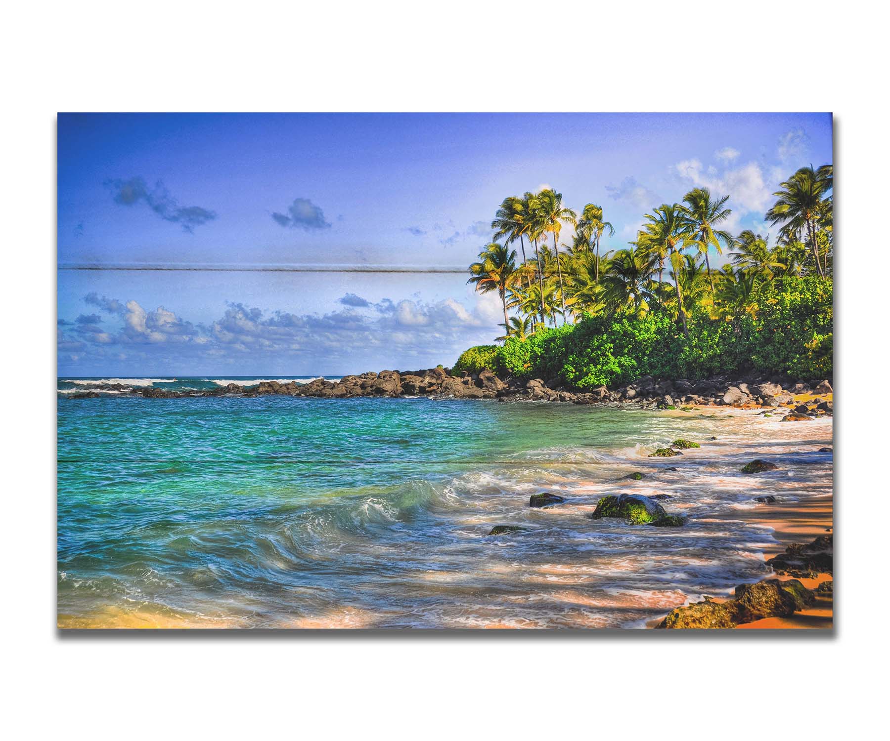 A photo of Laniākea beach. The water is a vibrant blue-green, and the stony beach circles around in the background where lush foliage and palm trees grow under a bright blue sky. Printed on a box board.