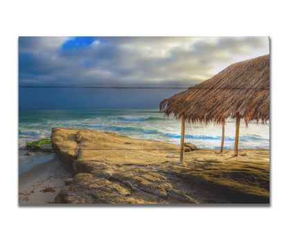 A photo of the palapa at Windansea beach, sitting on a rock in  the fading sunshine. Printed on a box board.