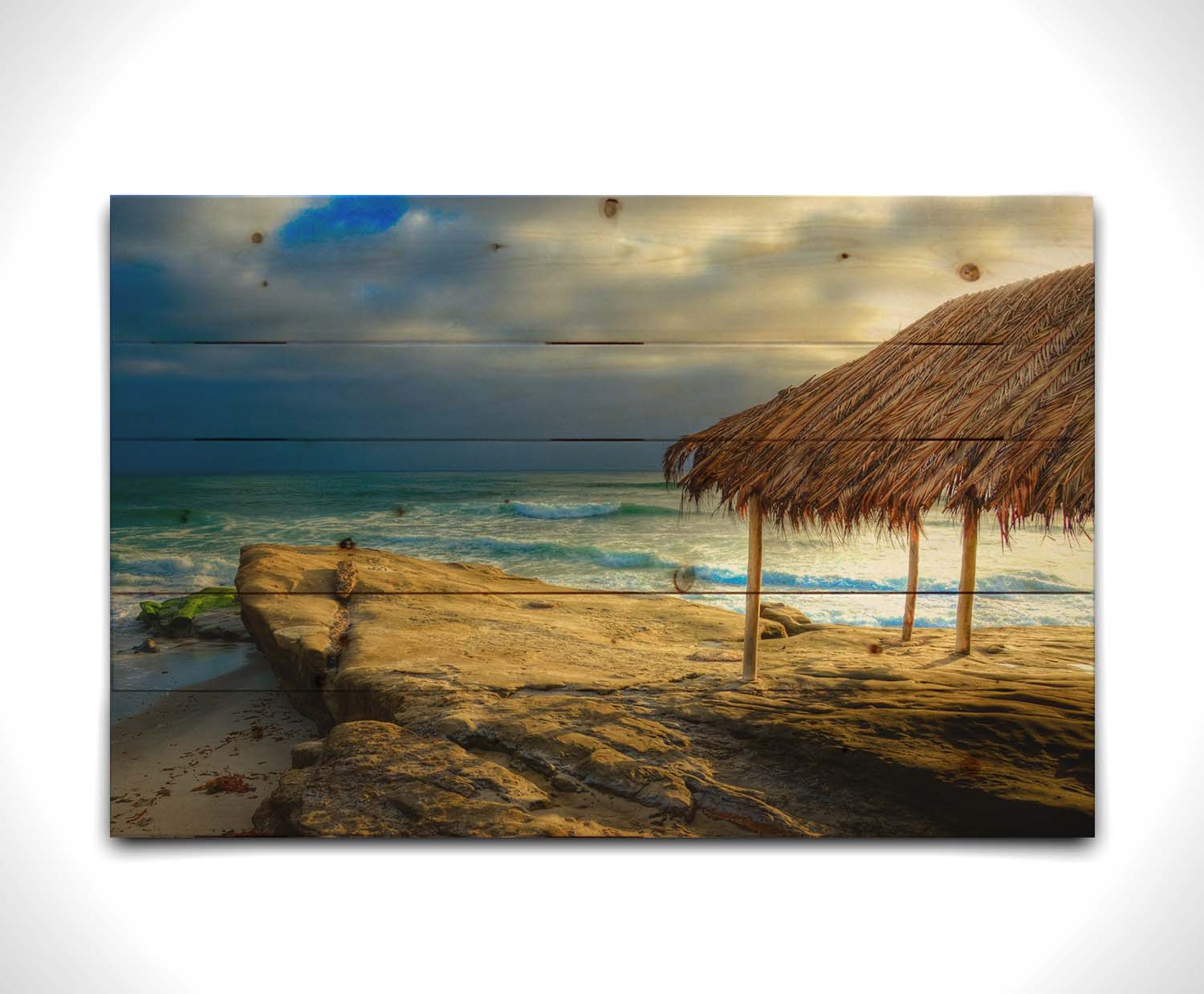 A photo of the palapa at Windansea beach, sitting on a rock in  the fading sunshine. Printed on a wood pallet.