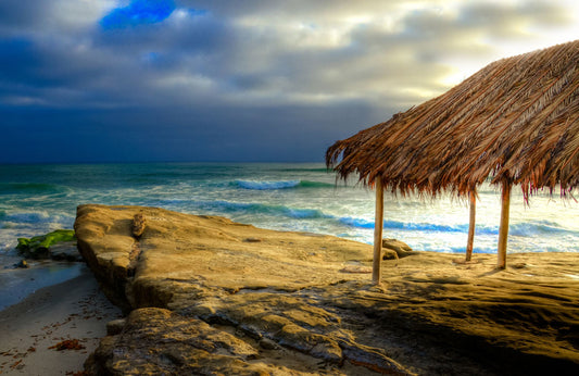 A photo of the palapa at Windansea beach, sitting on a rock in the fading sunshine.