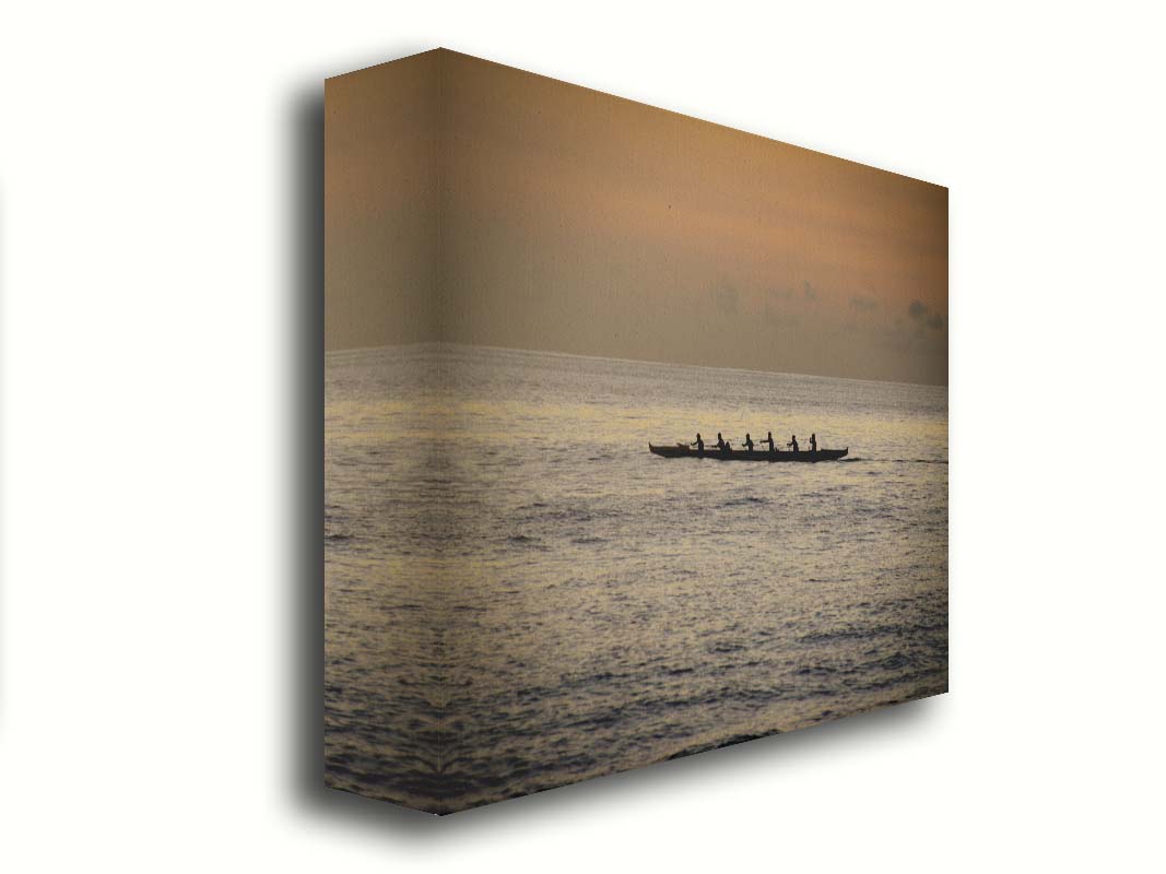 A photo of an outrigger canoe at sea, silhouetted against an orange sky. Printed on canvas.