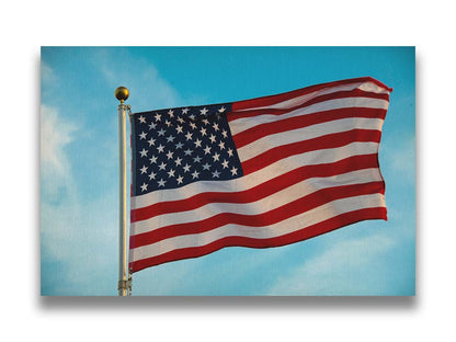 A photo of an American flag agsinst a bright blue sky. Printed on canvas.