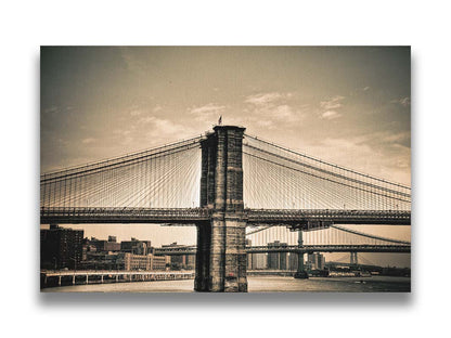 A sepia photo of the brooklyn bridge from the side, accented with a dark vignette. Printed on canvas.