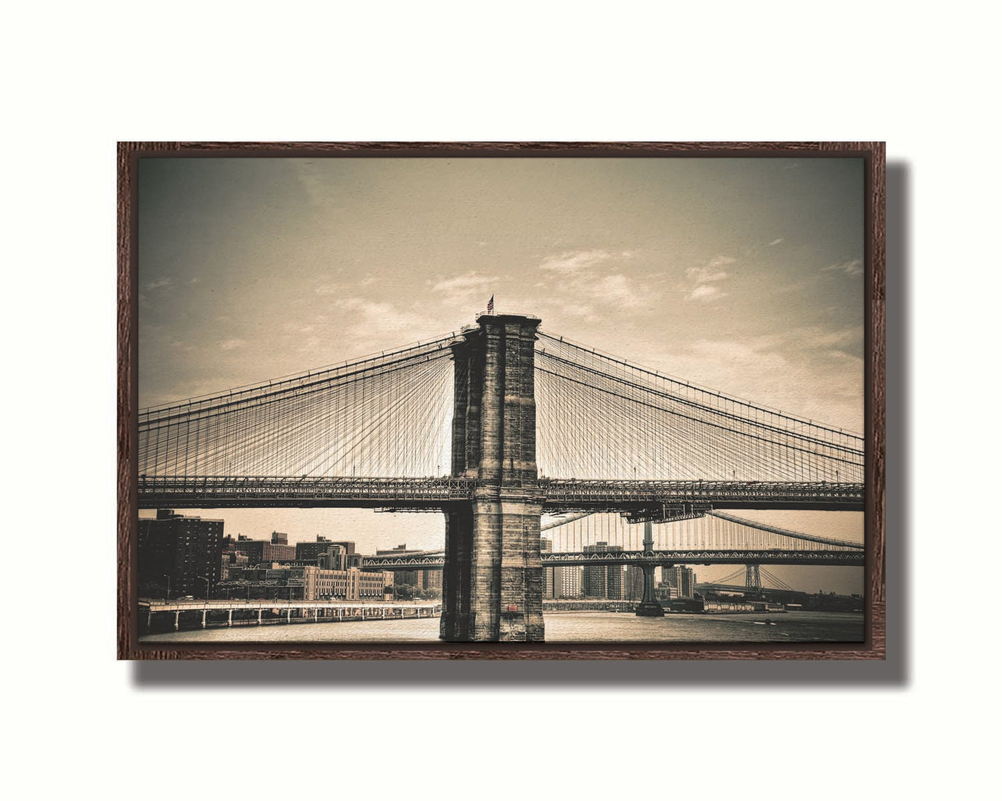 A sepia photo of the brooklyn bridge from the side, accented with a dark vignette. Printed on canvas in a float frame.