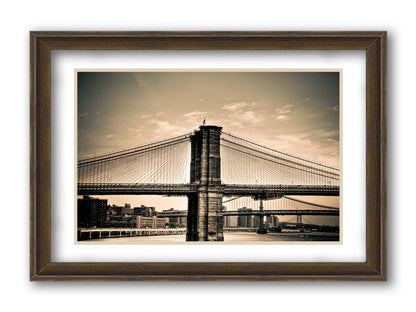 A sepia photo of the brooklyn bridge from the side, accented with a dark vignette. Printed on paper, matted, and framed.