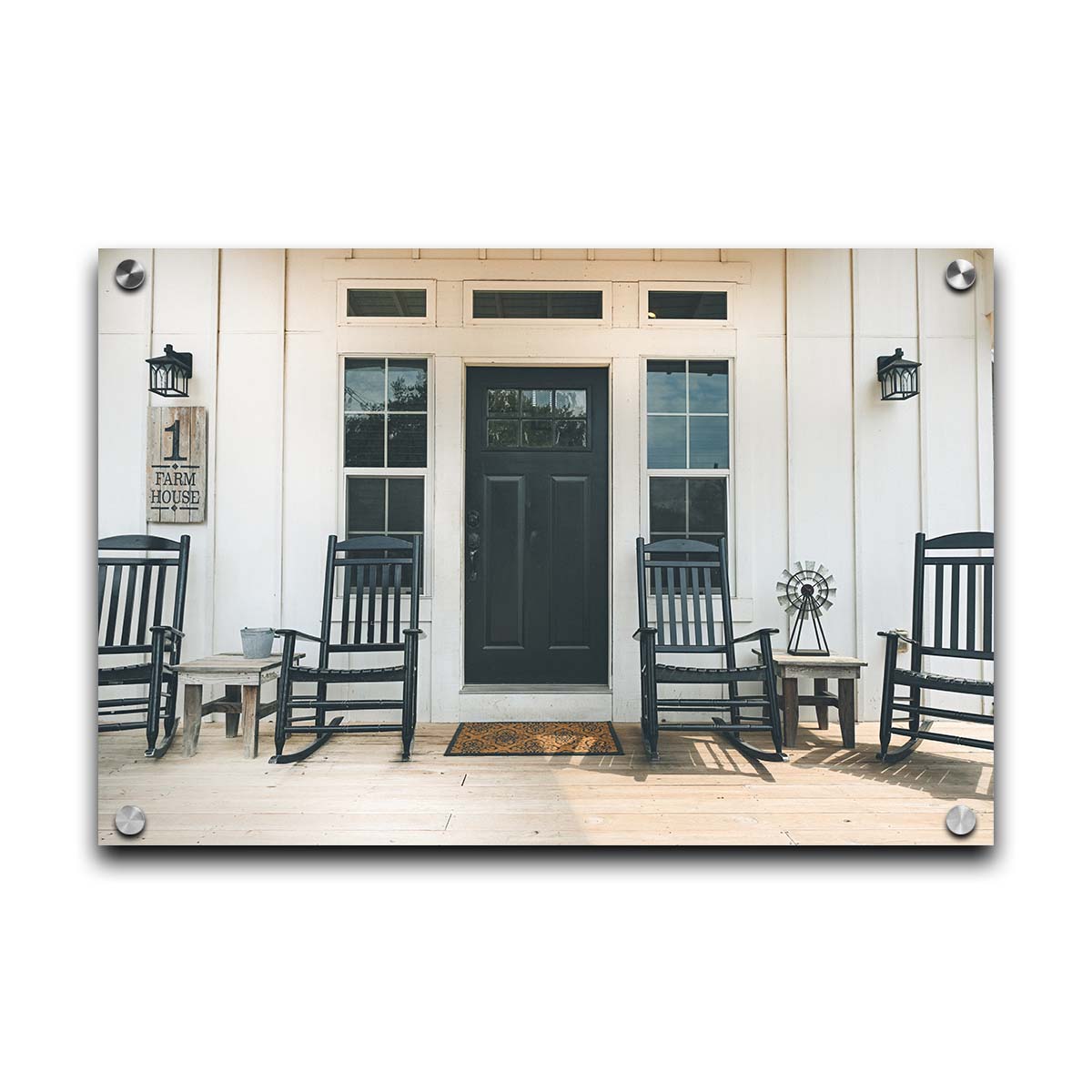 A photo of the door and front porch of a white house, with four black rocking chairs and a black door. Printed on acrylic.