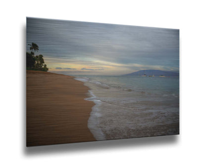 A photo of a cloudy sunrise on the Kaʻanapali shore, looking out to sea. Sailboats can be seen out on the water. Printed on metal.