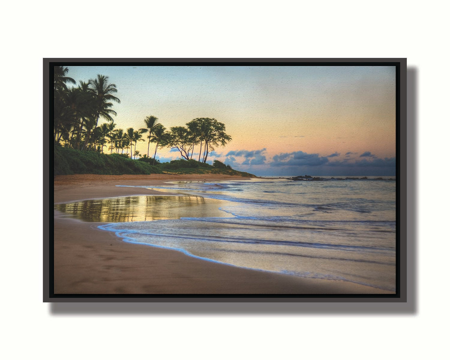 A photo of Keawakapu Beach at sunrise, with palms and mountains in the distance. Printed on canvas in a float frame.