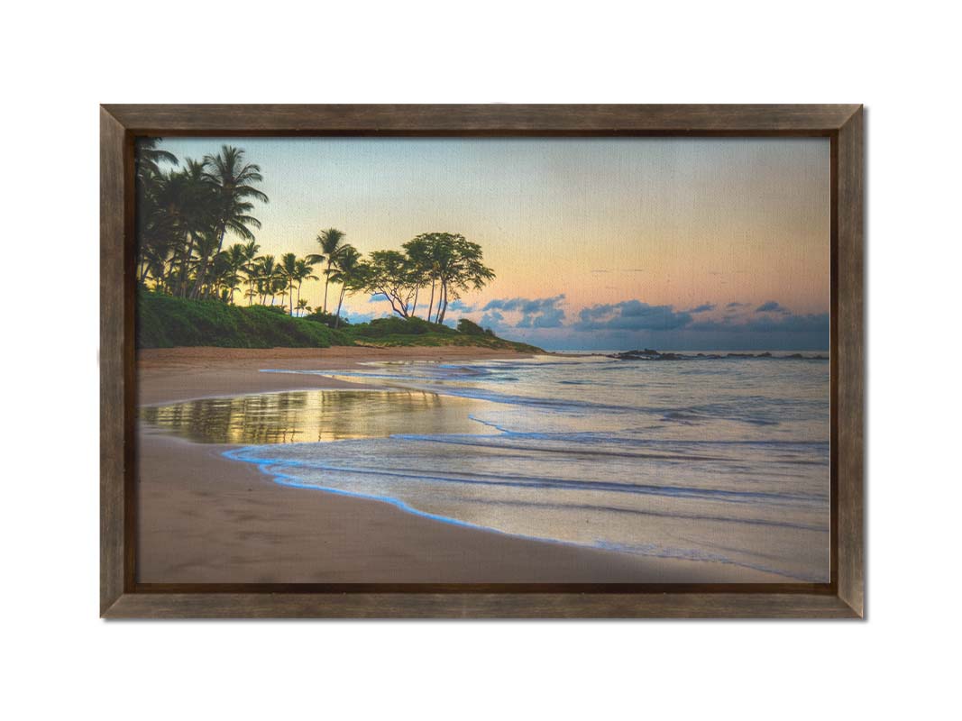 A photo of Keawakapu Beach at sunrise, with palms and mountains in the distance. Printed on canvas and framed.