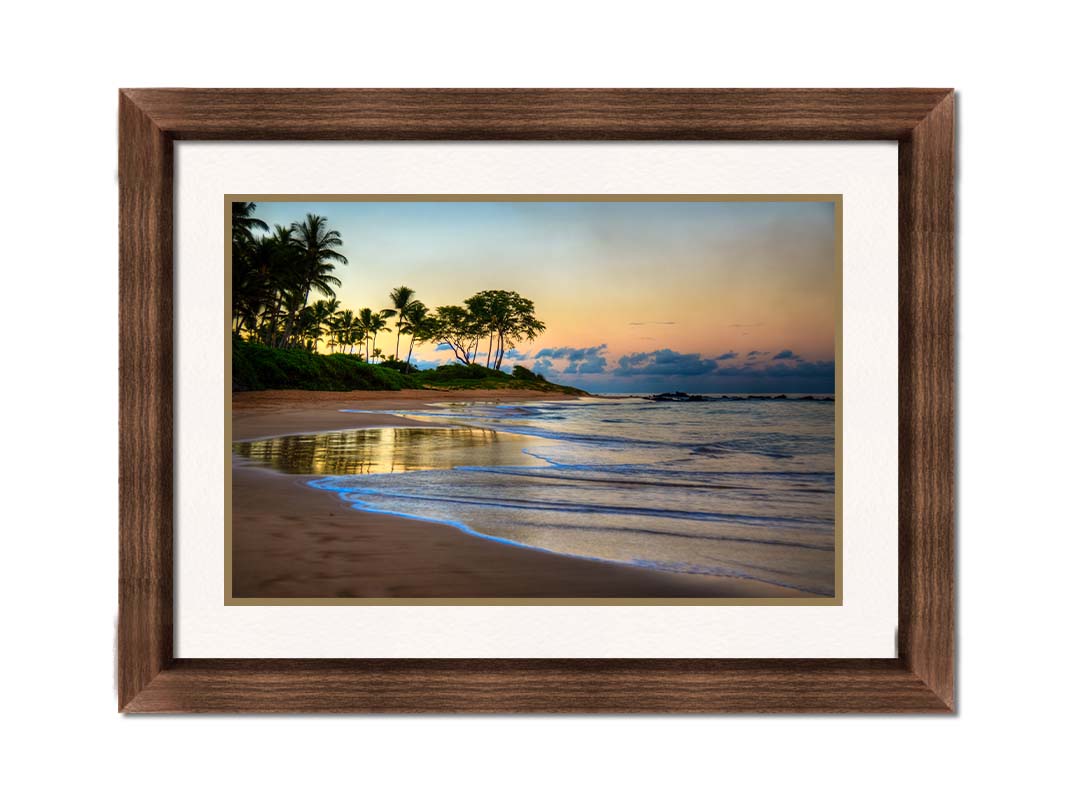 A photo of Keawakapu Beach at sunrise, with palms and mountains in the distance. Printed on paper, matted, and framed.