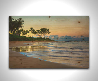 A photo of Keawakapu Beach at sunrise, with palms and mountains in the distance. Printed on a wood pallet.