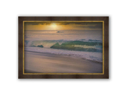 A photo of a calm sea wave rolling onto the beach on Maui at sunset. A boat can be seen on the water in the distance. Printed on canvas and framed.