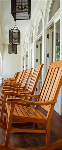 A photo looking down a row of rocking chairs on a porch in O'ahu, Hawaiʻi. 