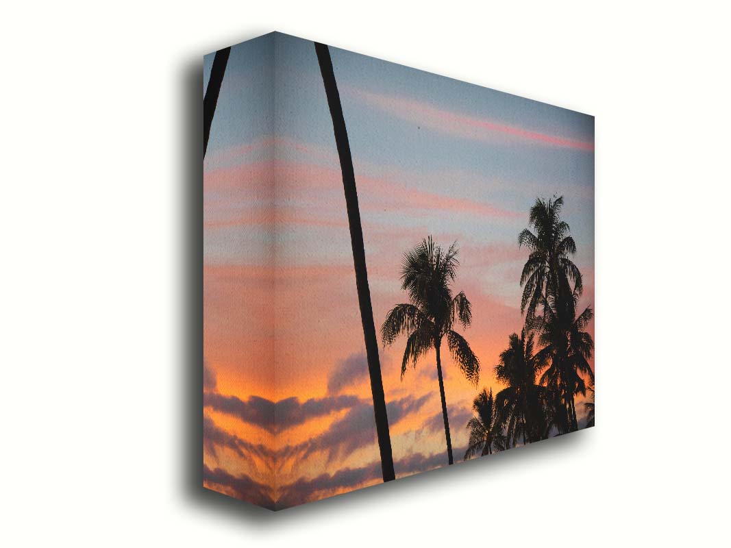 A photograph of Hawaiʻian palm trees, sihouetted against a sunset sky in orange, pink, and blue. Printed on canvas.