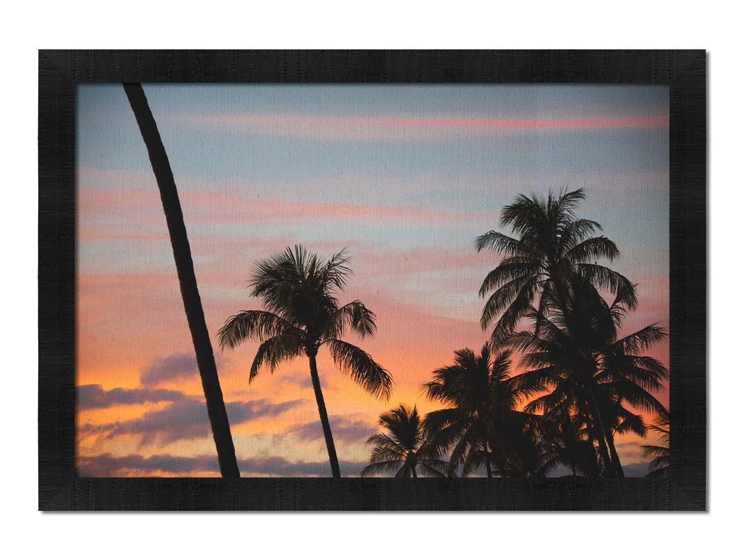 A photograph of Hawaiʻian palm trees, sihouetted against a sunset sky in orange, pink, and blue. Printed on canvas and framed.