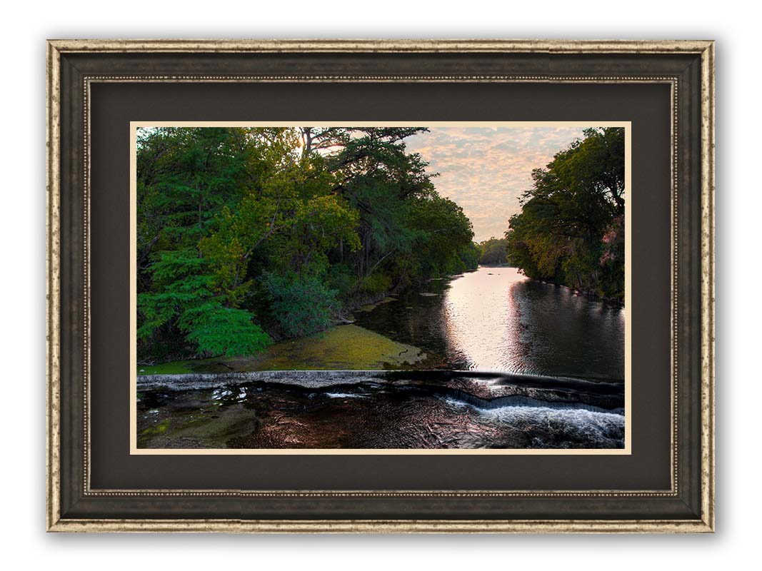 A photograph of the Comal River in New Braunfels, Texas. Printed on paper, matted, and framed.