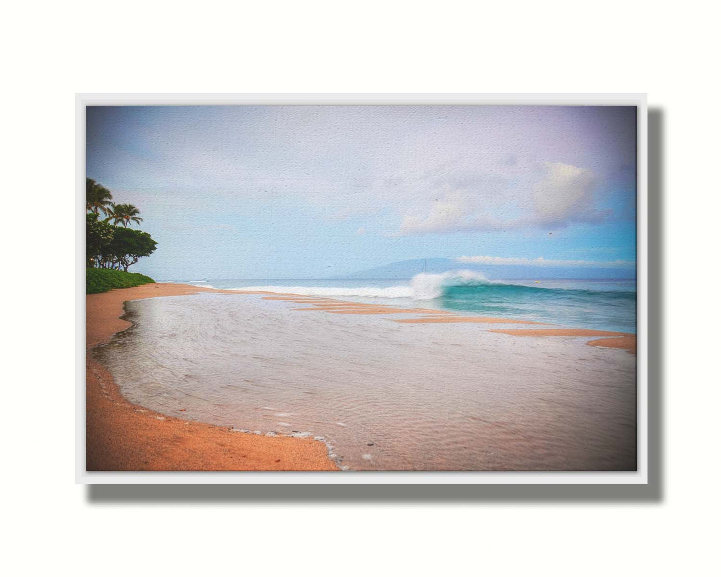 A refreshing photograph of Hawai'i's Ka'anapali beach, with cool blue waves rolling onto shore and mountains in the distance. Printed on canvas in a float frame.