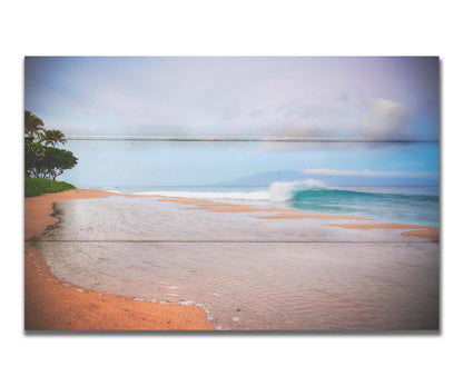 A refreshing photograph of Hawai'i's Ka'anapali beach, with cool blue waves rolling onto shore and mountains in the distance. Printed on a box board.