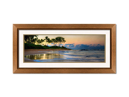 A photo of Keawakapu Beach at sunrise, with palms and mountains in the distance. Printed on paper, matted, and framed.