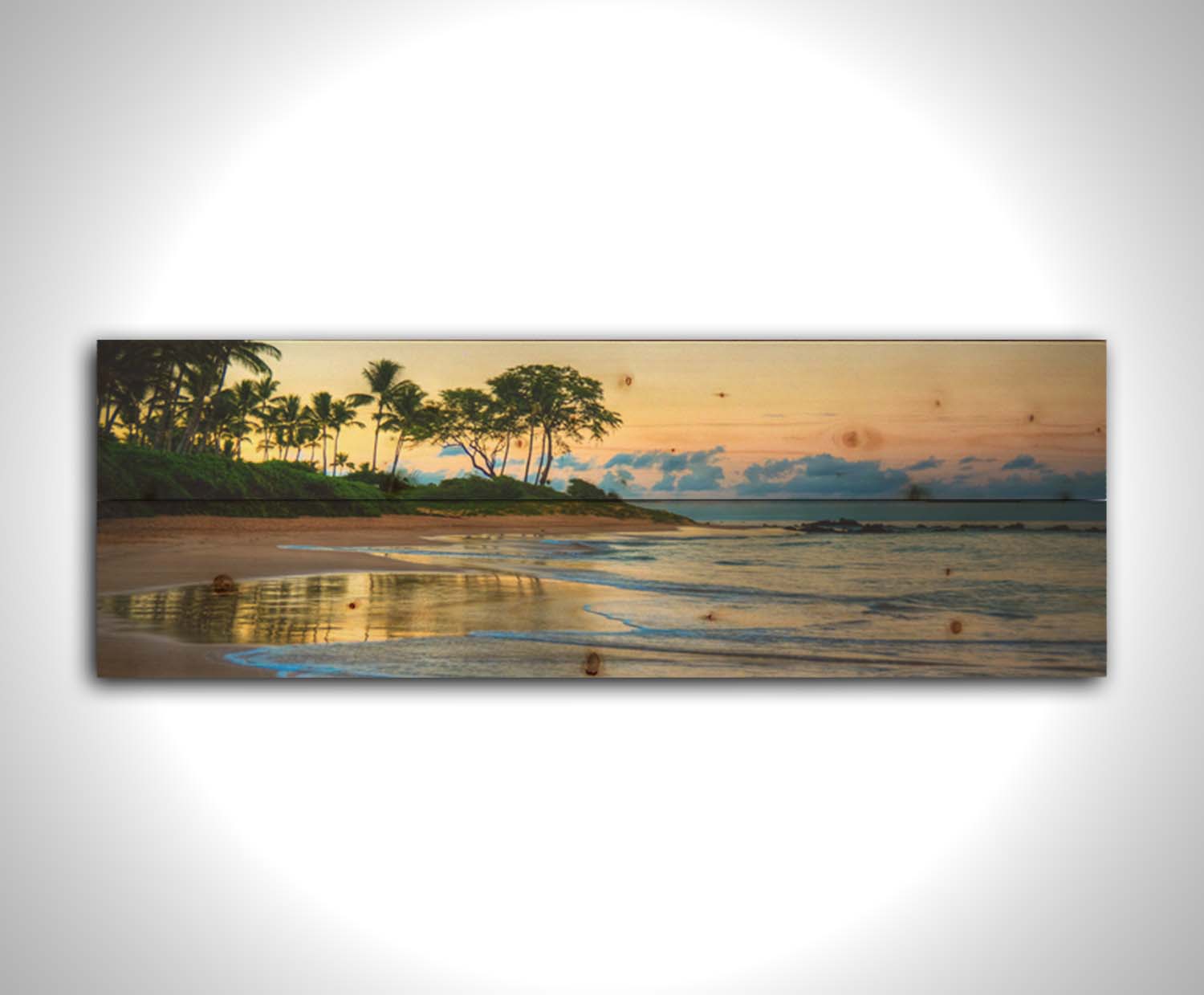 A photo of Keawakapu Beach at sunrise, with palms and mountains in the distance. Printed on a wood pallet.