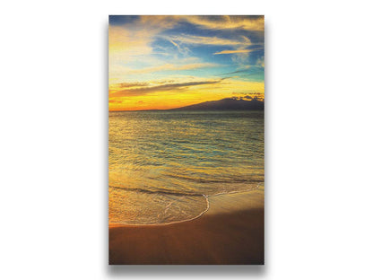 A photograph of a colorful sunset with a majestic mountain on the horizon, looking out over the sea on the coast of Maui, Hawaiʻi. Printed on canvas.