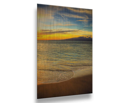 A photograph of a colorful sunset with a majestic mountain on the horizon, looking out over the sea on the coast of Maui, Hawaiʻi. Printed on metal.