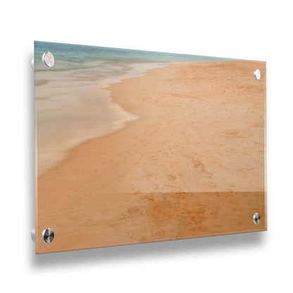 A photograph of beach sand. The warm hues of golden sand are contrasted by the cool ocean water. Printed on acrylic.