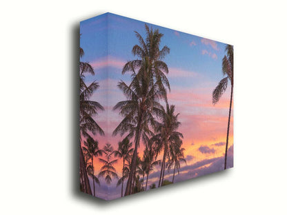 A photograph of Hawaiʻian palm trees, backed by a sunset sky in orange, pink, and blue. Printed on canvas.