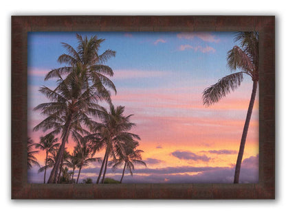 A photograph of Hawaiʻian palm trees, backed by a sunset sky in orange, pink, and blue. Printed on canvas and framed.