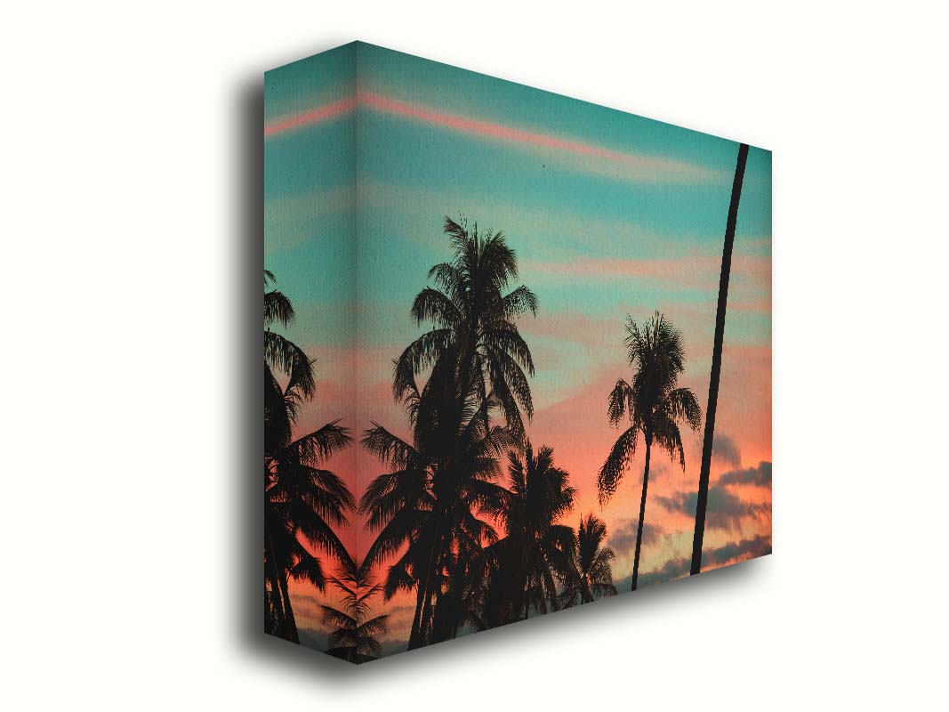 A photograph of Hawaiʻian palm trees, sihouetted against a sunset sky in orange, pink, and blue. Printed on canvas.